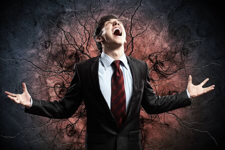 businessman in anger with fists clenched screamingの写真素材