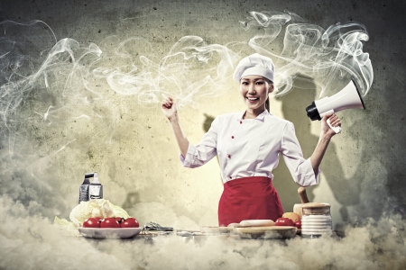Asian female young cook smiling holding megaphoneの写真素材