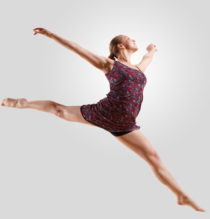 Girl dancing in a color dress with a gray background  isolateの写真素材