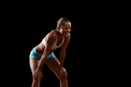 Fitness woman smiling standing against black backgroundの写真素材