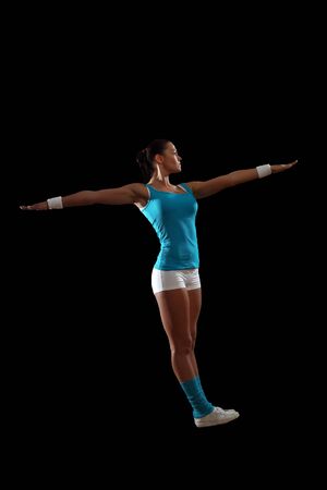 Fitness woman smiling standing against black backgroundの写真素材
