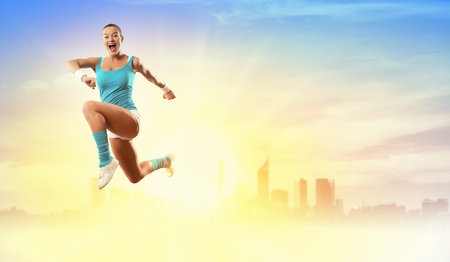 Image of sport girl in jump against city backgroundの写真素材