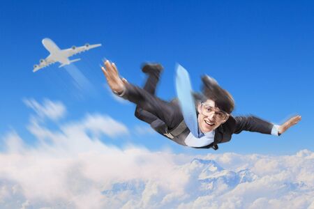 Conceptual image of young businessman flying with parachute on backの写真素材