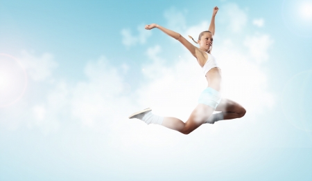 Image of sport girl in jump against cloudy backgroundの写真素材