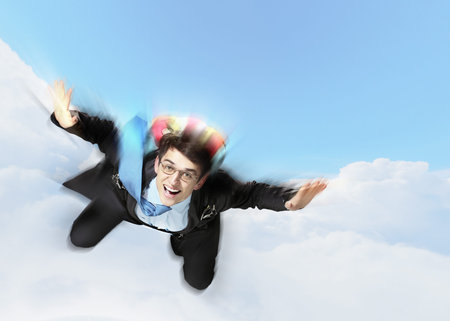 Conceptual image of young businessman flying with parachute on back
