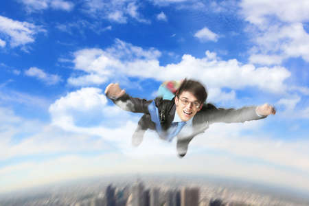 Conceptual image of young businessman flying with parachute on backの写真素材