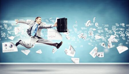 Image of a businessman jumping high against financial backgroundの写真素材