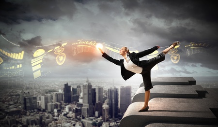Image of pretty businesswoman balancing on the roof above cityscapeの写真素材