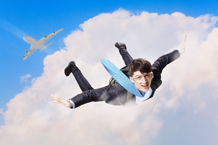 Conceptual image of young businessman flying with parachute on backの写真素材