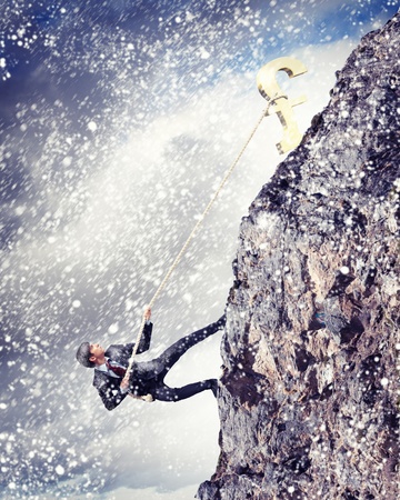 businessman climbing hill with pound on topの写真素材