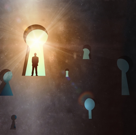 Silhouette of businessman standing in keyhole sun shining aboveの写真素材