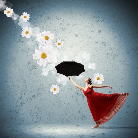 ballet dancer in flying satin dress with umbrella and flowersの写真素材