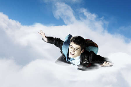 Conceptual image of young businessman flying with parachute on backの写真素材