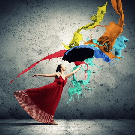 ballet dancer in flying satin dress with umbrella under the paintの写真素材