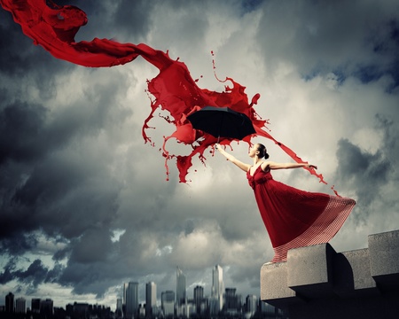 ballet dancer in flying satin dress with umbrella under the paintの写真素材