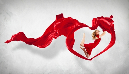 Portrait of a dancing young woman with red fabricの写真素材