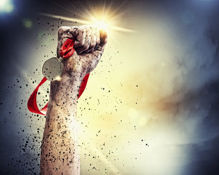 Hand held medal against a stormy skyの写真素材