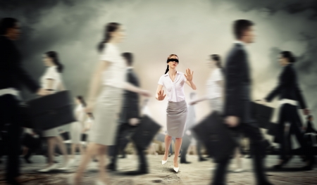 Image of businesswoman in blindfold walking among group of peopleの写真素材