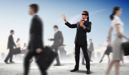 Image of businessman in blindfold walking among group of peopleの写真素材