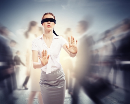 Image of businesswoman in blindfold walking among group of peopleの写真素材
