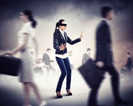 Image of businesswoman in blindfold walking among group of peopleの写真素材
