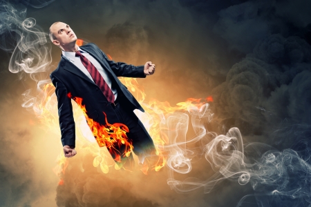 Image of young businessman in anger burning in fireの写真素材