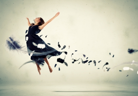 Young girl flying among the feathers like a birdの写真素材
