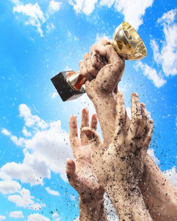 Hands squeeze the coup winner against lightning blue sky の写真素材