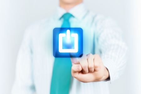 Young man in a light shirt and blue tie press the power button  Shallow depth of field の写真素材