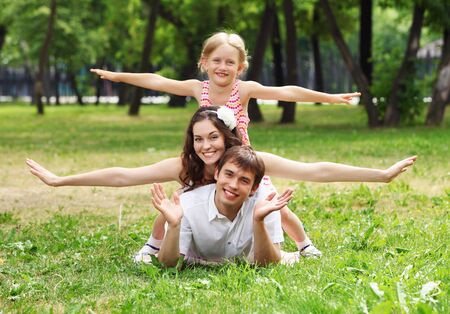Young Family Outdoors on the grass in Park in summerの写真素材