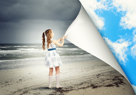 Little girl turning page with another realityの写真素材