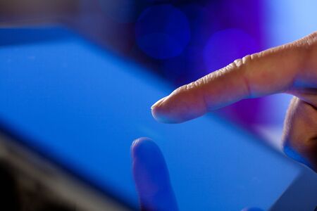 Close-up image of finger touching blue screenの写真素材