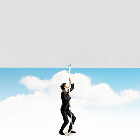 Image of businessman pulling blank banner  Place for textの写真素材