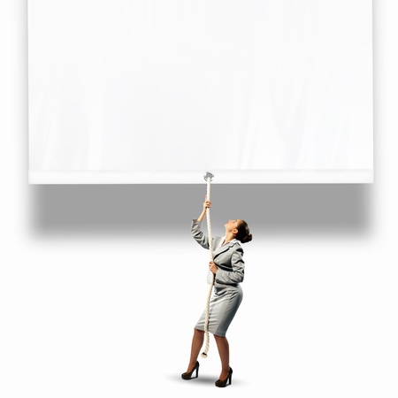 Image of businesswoman pulling blank banner  Place for textの写真素材