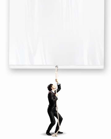 Image of businessman pulling blank banner  Place for textの写真素材