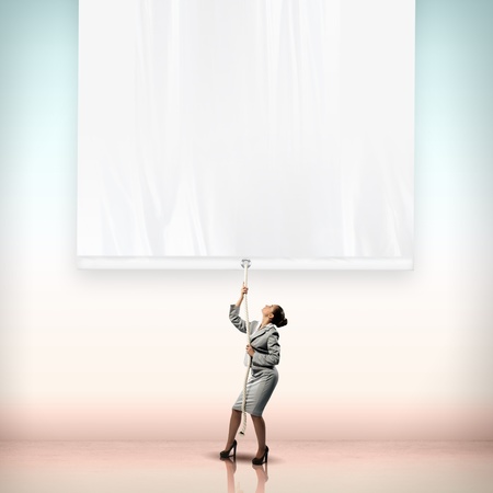 Image of businesswoman pulling blank banner  Place for textの写真素材