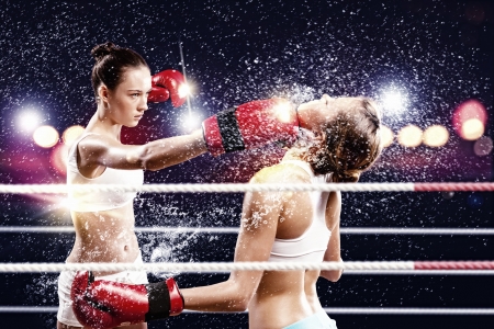 Two young pretty women boxing in ringの写真素材