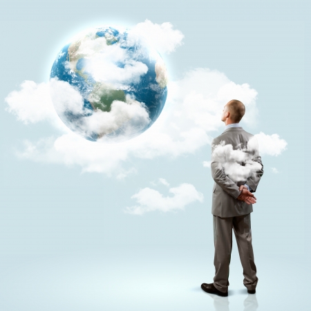 Image of thoughtful businessman standing with back  Elements of this image are furnished by NASAの写真素材