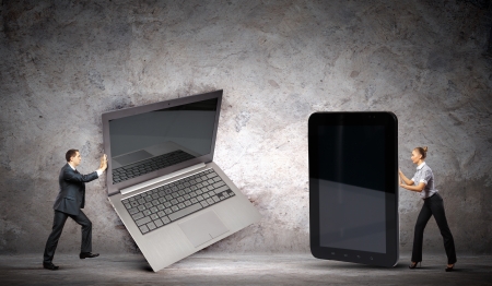 Two businesspeople with laptop and ipad in macro sizeの写真素材