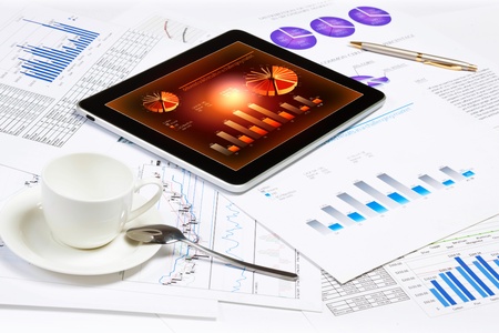 Image of cup of coffee and tablet laying on business documentsの写真素材