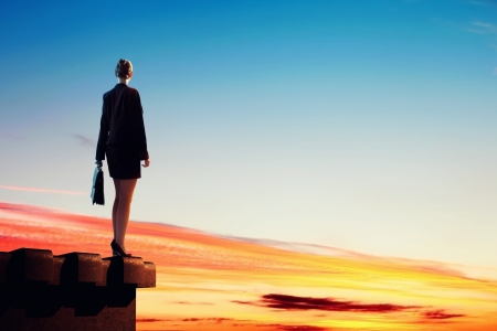 Image of young businesswoman standing on top of buildingの写真素材