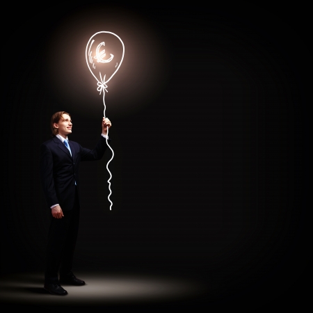 Image of businessman in black suit against dark backgroundの写真素材