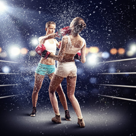 Two young pretty women boxing in ring