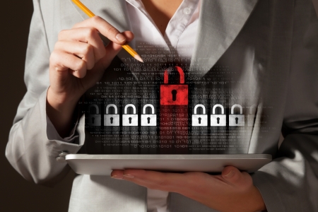 Businesswoman holding tablet pc entering password  Security conceptの写真素材