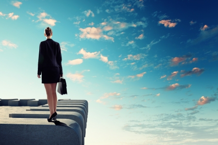 Image of young businesswoman standing on top of buildingの写真素材