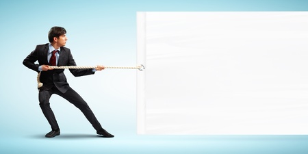 Image of businessman pulling blank banner  Place for textの写真素材
