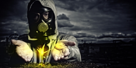 Young man in a protective suit touches to the sprout  post-nuclear futureの写真素材