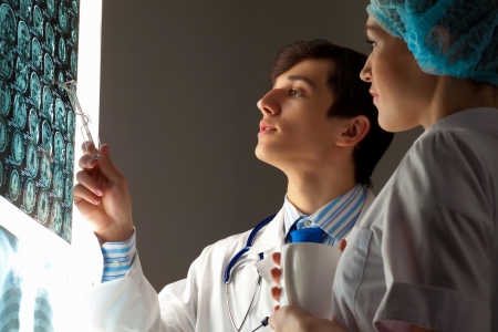 Image of two young two doctors discussing x-ray resultsの写真素材