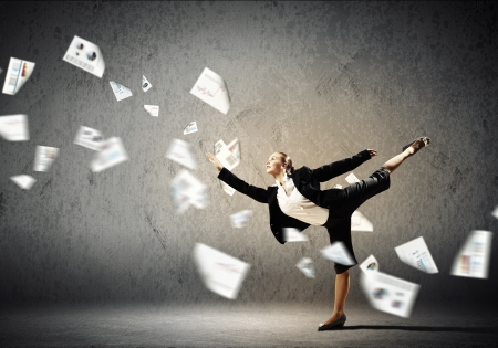 Image of pretty businesswoman jumping high against financial backgroundの写真素材