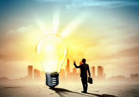 Image of businessman looking at light bulb  Green energy conceptの写真素材